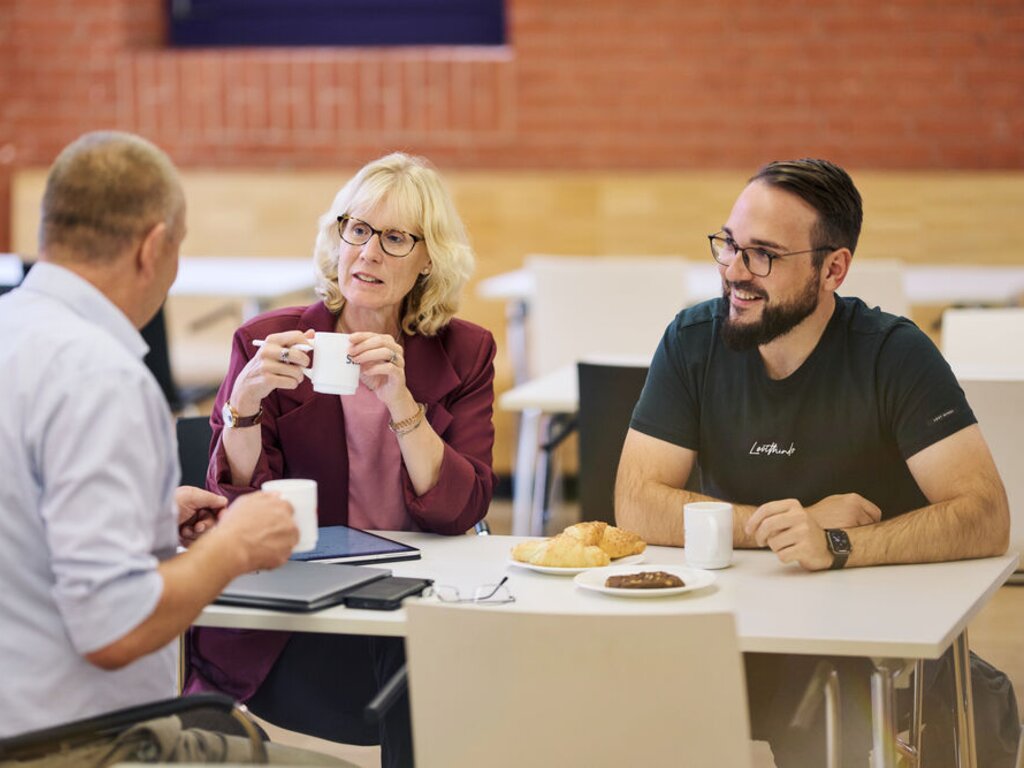 Eine Gruppe Mitarbeiter:innen in unserer Cafeteria