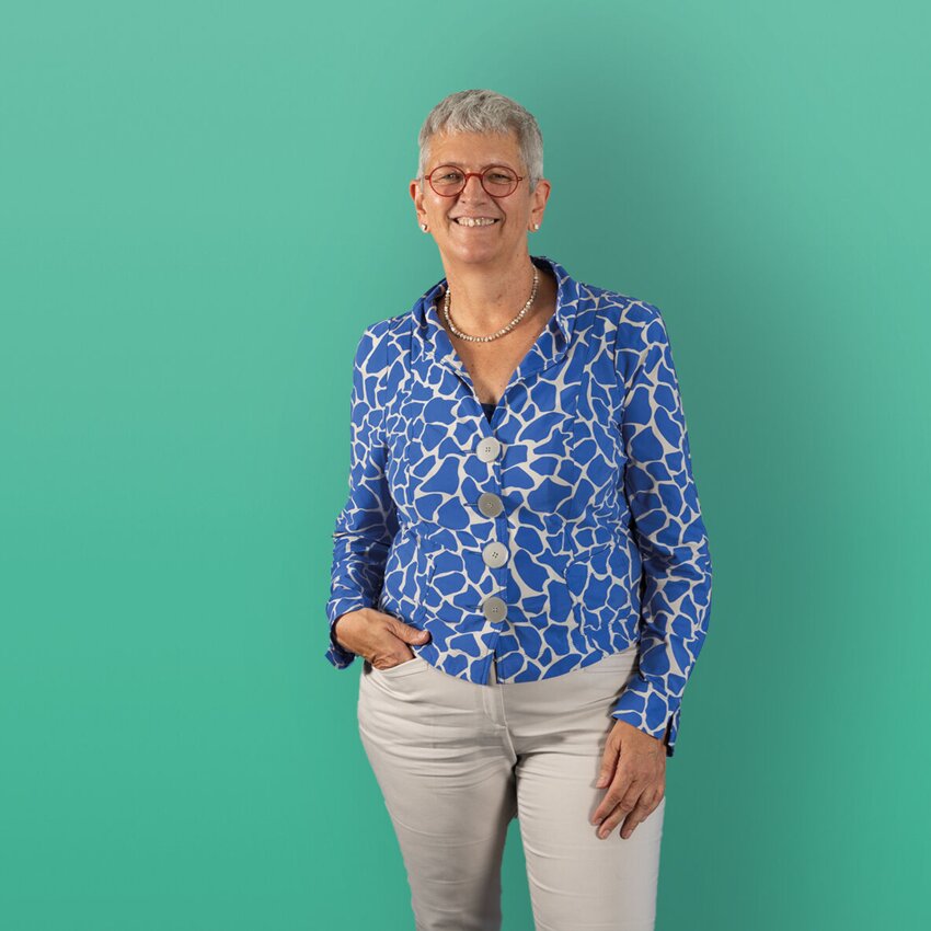 Karin Vosseberg stehend vor einem grünen Hintergrund