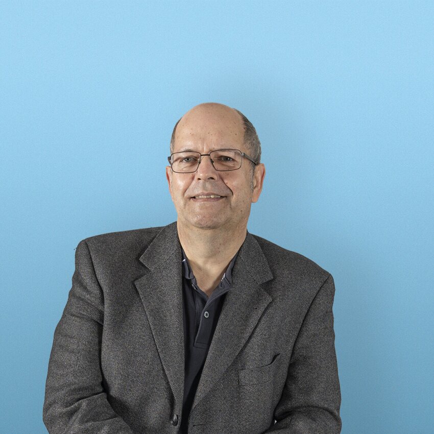 Rainer Benning stehend vor einem blauen Hintergrund
